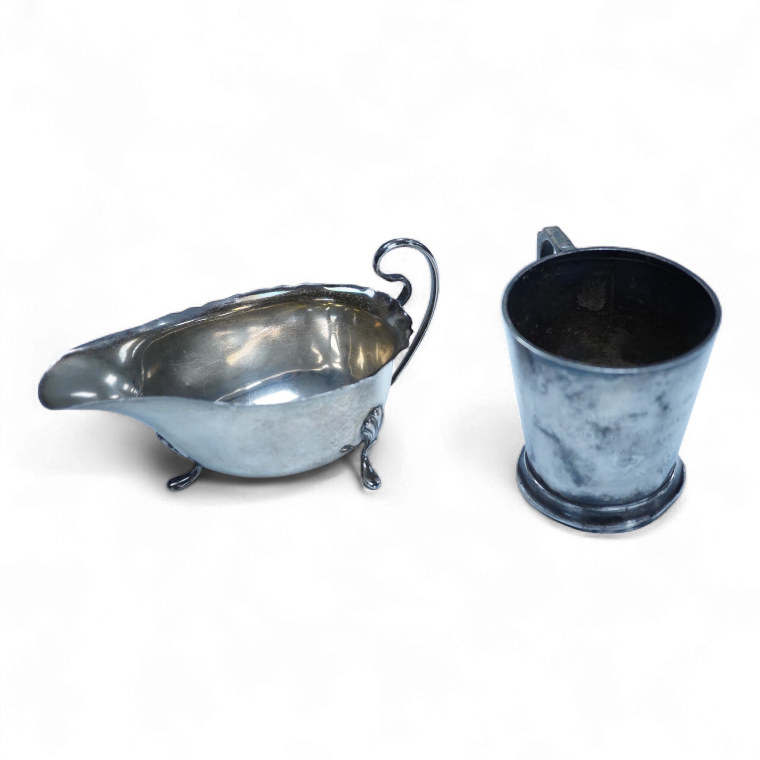 A George V silver sauceboat, by William Neale Ltd, Birmingham, 1925, length 14.6cm, together with a 1950's small silver mug, 6.6oz.